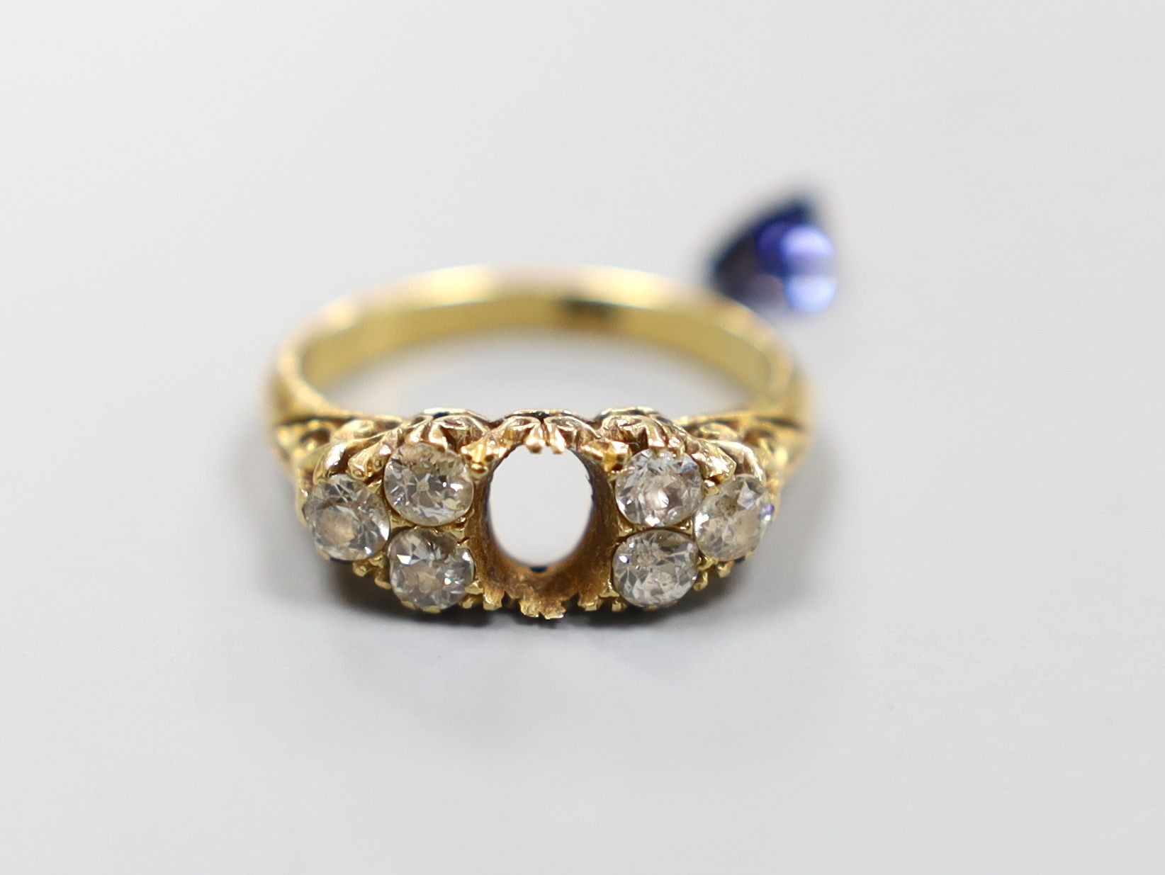 An early 20th century 18ct, single stone sapphire and six stone diamond cluster set half hoop ring, size O, gross 4.4 grams(sapphire loose).